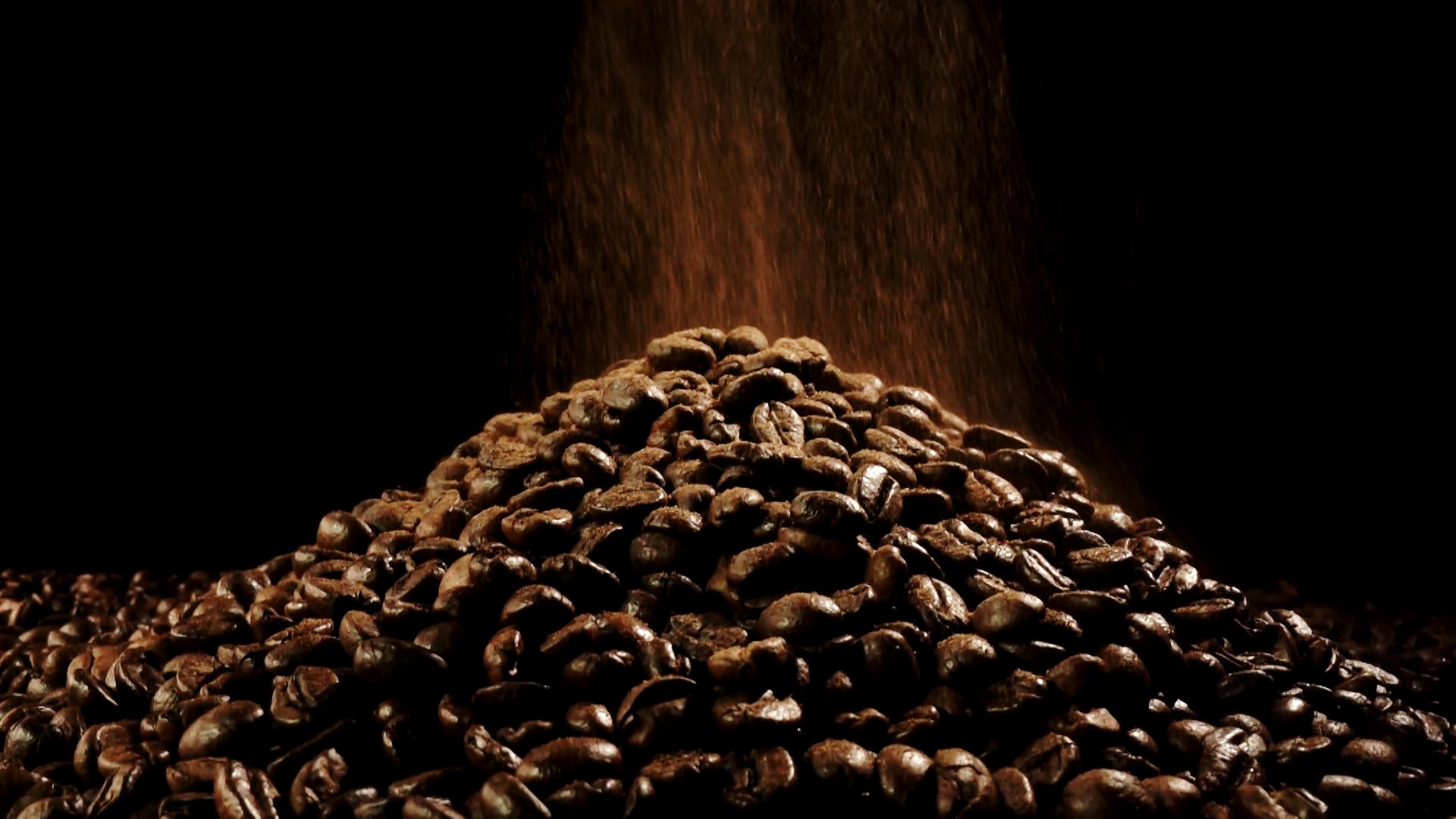 咖啡粉洒落在咖啡豆堆成的小山上视频的预览图