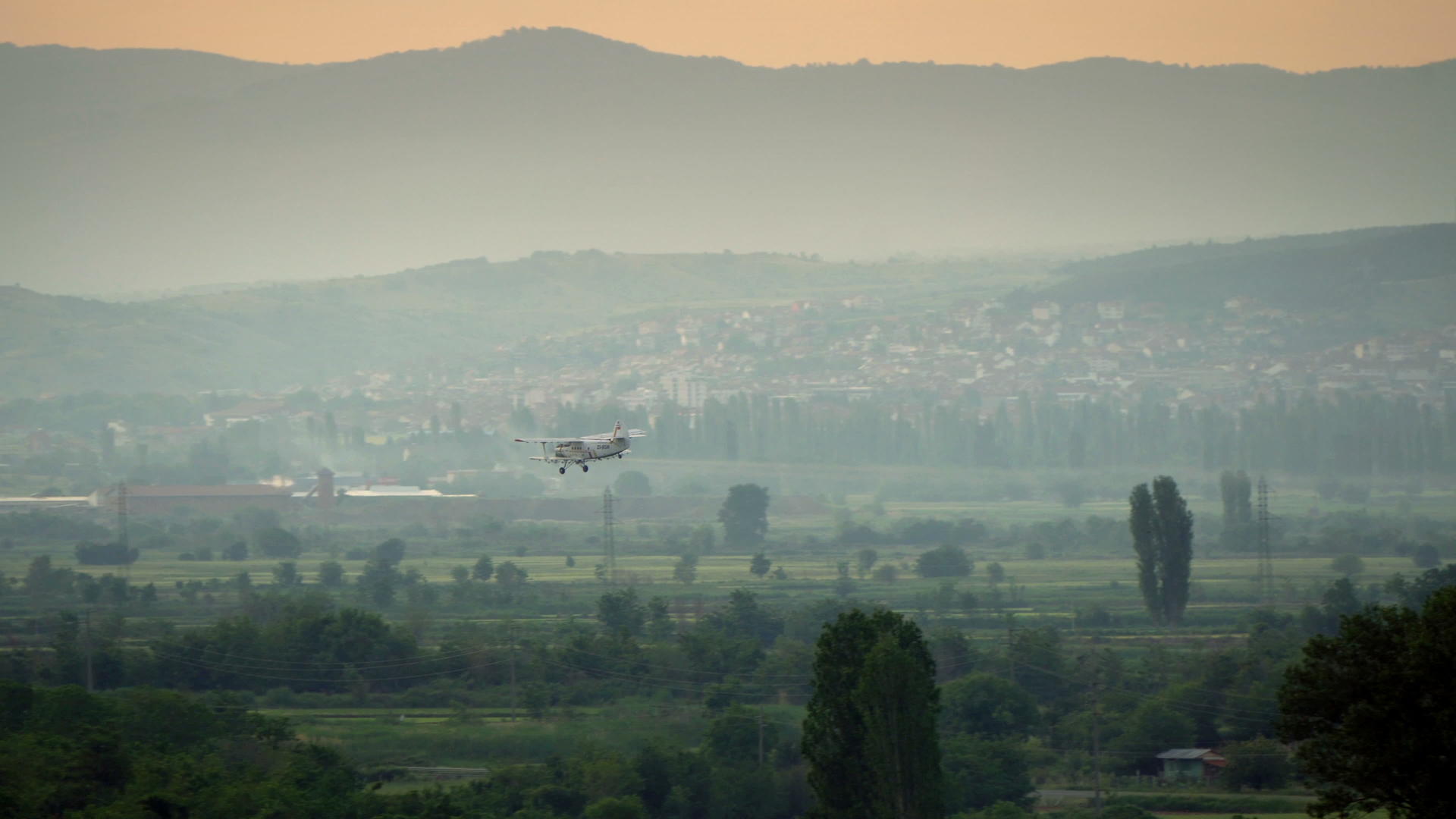 飞机在日出时向田地喷洒视频的预览图