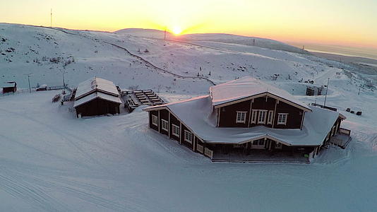 日落时飞过冬季滑雪中心视频的预览图