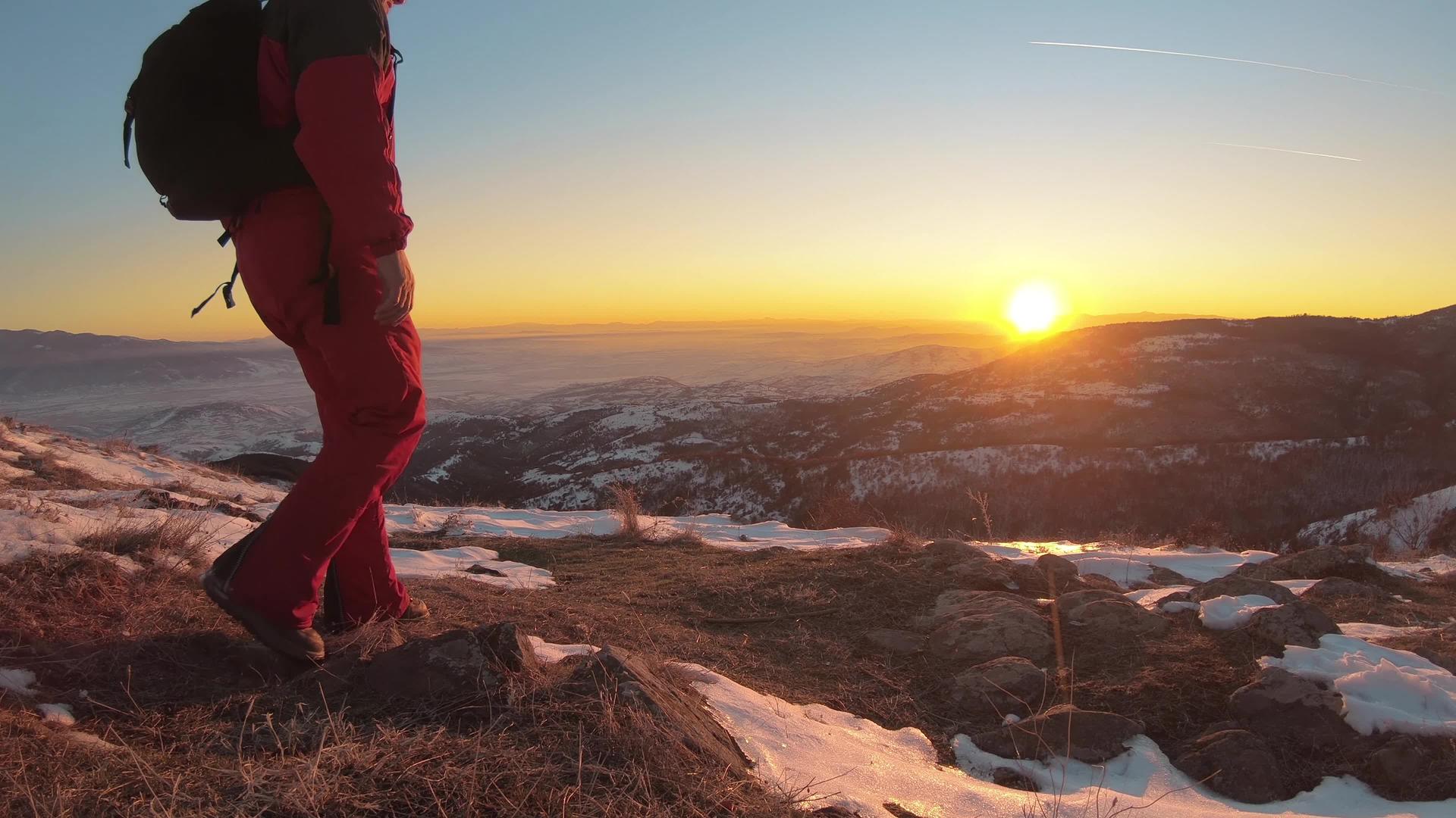 徒步旅行者在山顶山谷的新鲜雪地上放松享受壮丽的冬季日落视频的预览图