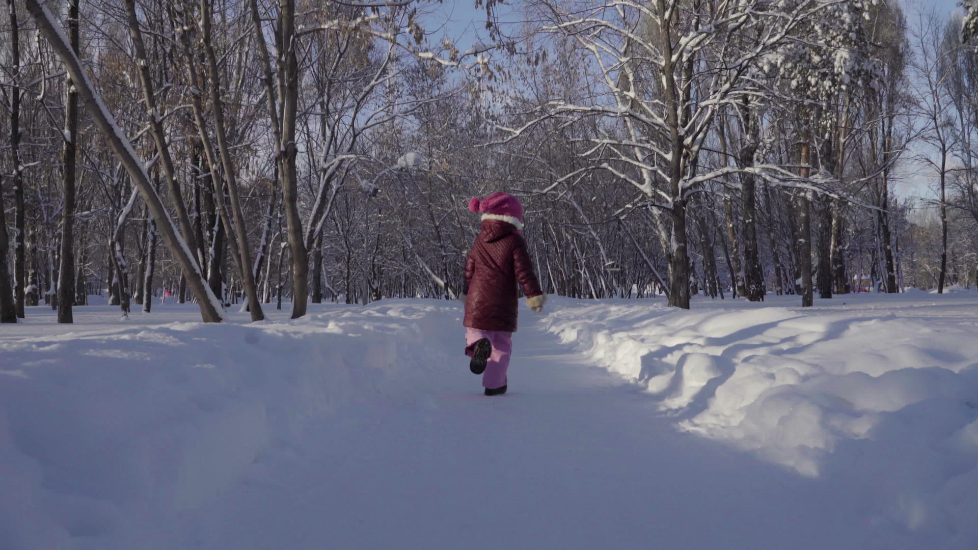 女孩在冬天的公园里跑来跑去视频的预览图
