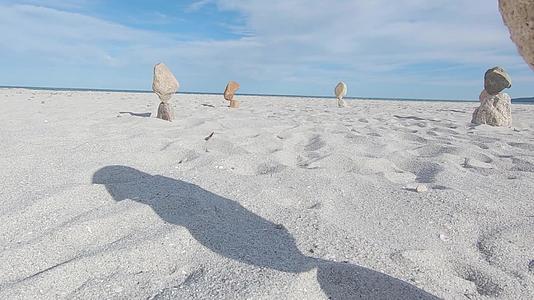 平衡的石头在白色沙滩的沙滩上视频的预览图
