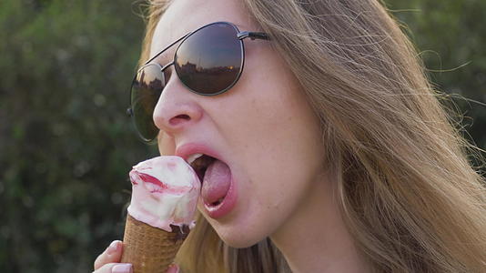 黑人年轻女性戴着太阳镜舔冰淇淋视频的预览图