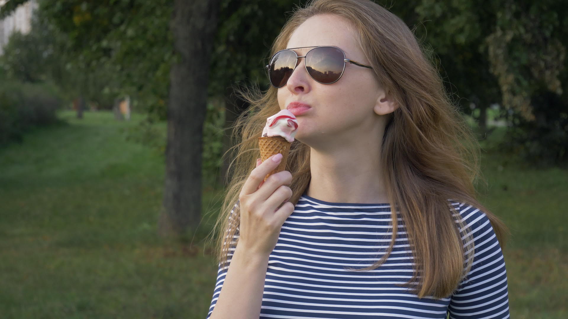 戴着太阳镜的年轻女孩正在吃冰淇淋视频的预览图
