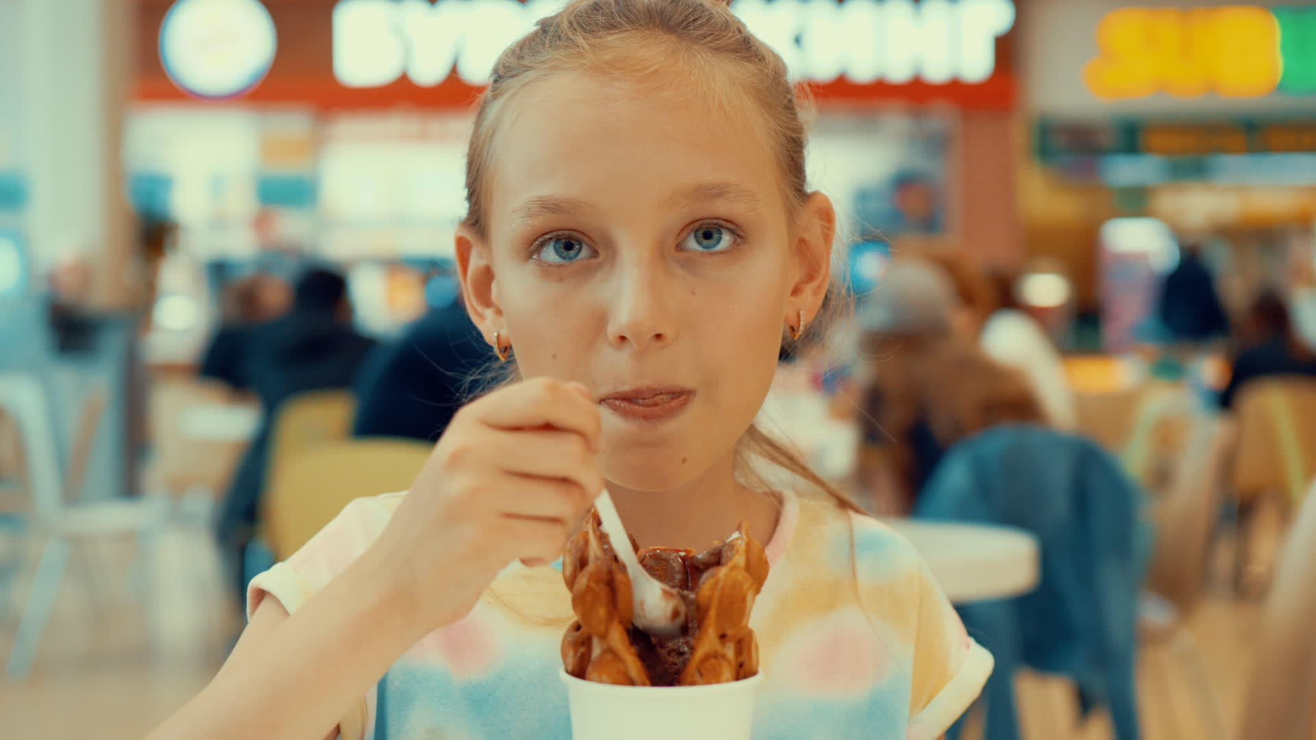 可爱的女孩在美食广场吃冰淇淋视频的预览图