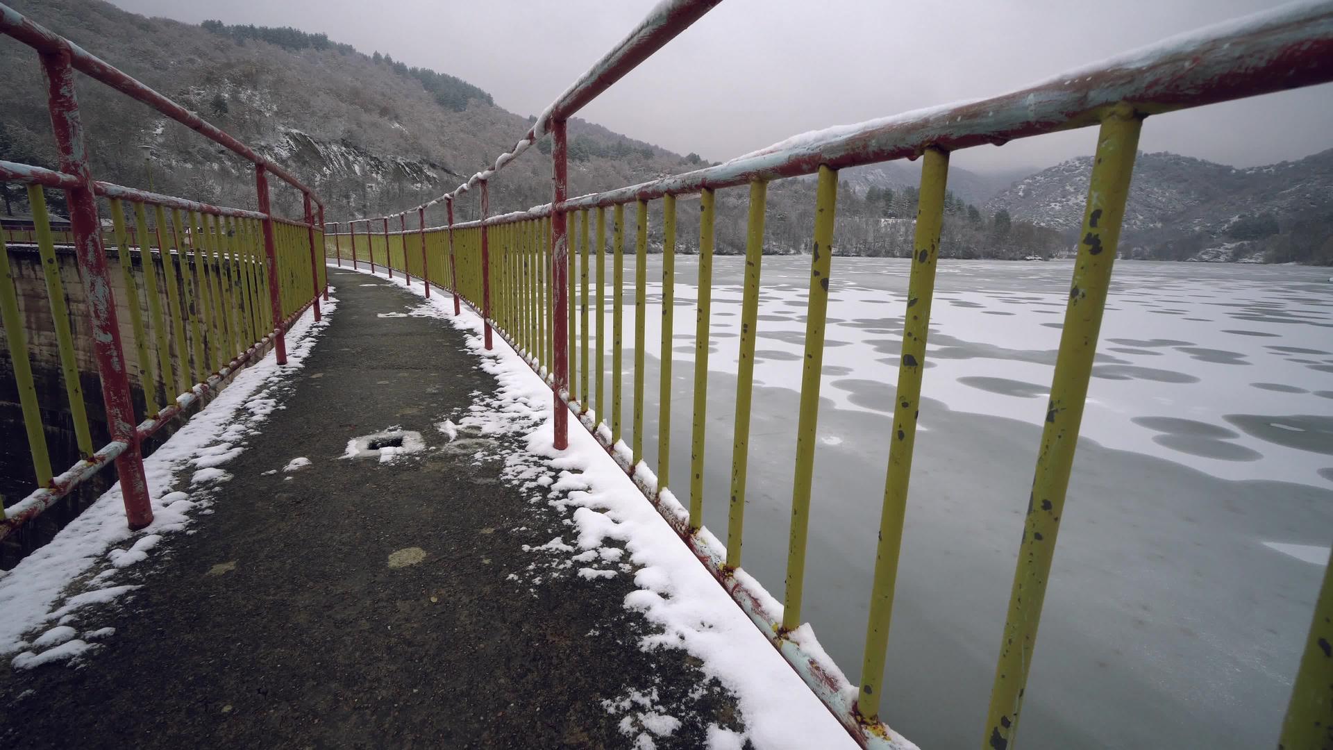 美丽的冬季风景来自冰冻的湖泊和雪林的桥梁视频的预览图