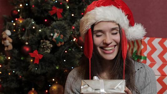 女人摇着圣诞礼盒视频的预览图