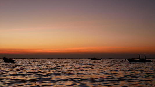 小船在日落海上的剪影视频的预览图