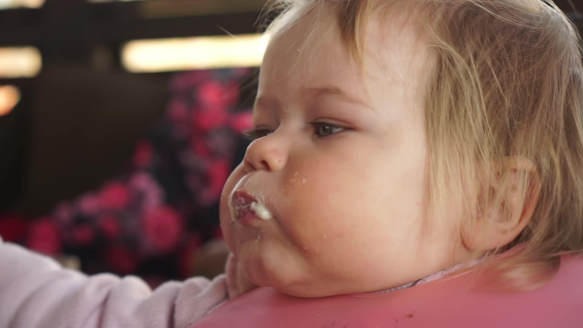 一岁的胖女婴从勺子张开的嘴里吃东西非常有趣视频的预览图