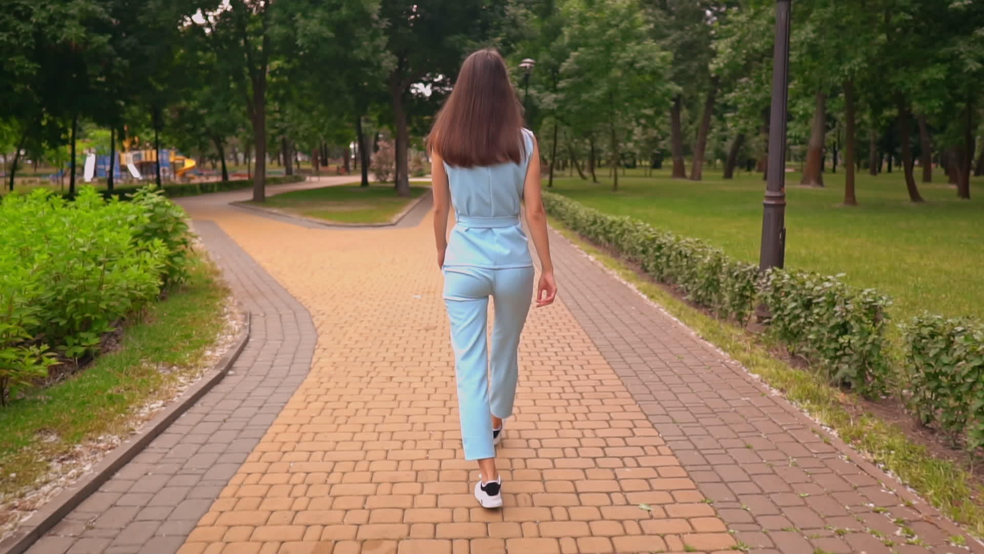 穿着临时西装的年轻女性在公园里散步视频的预览图
