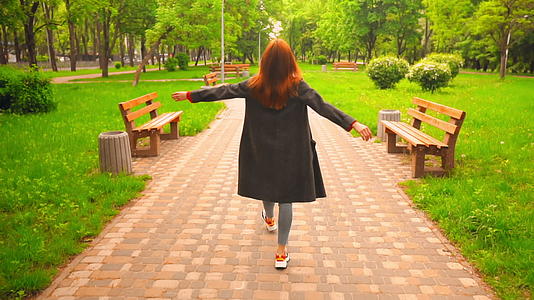 快乐的红发女人在公园里散步视频的预览图