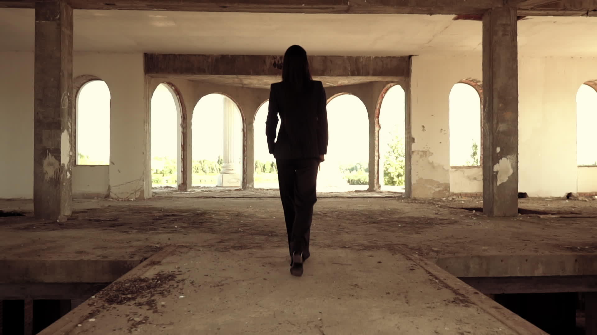 黑发女人走进废弃的建筑物视频的预览图