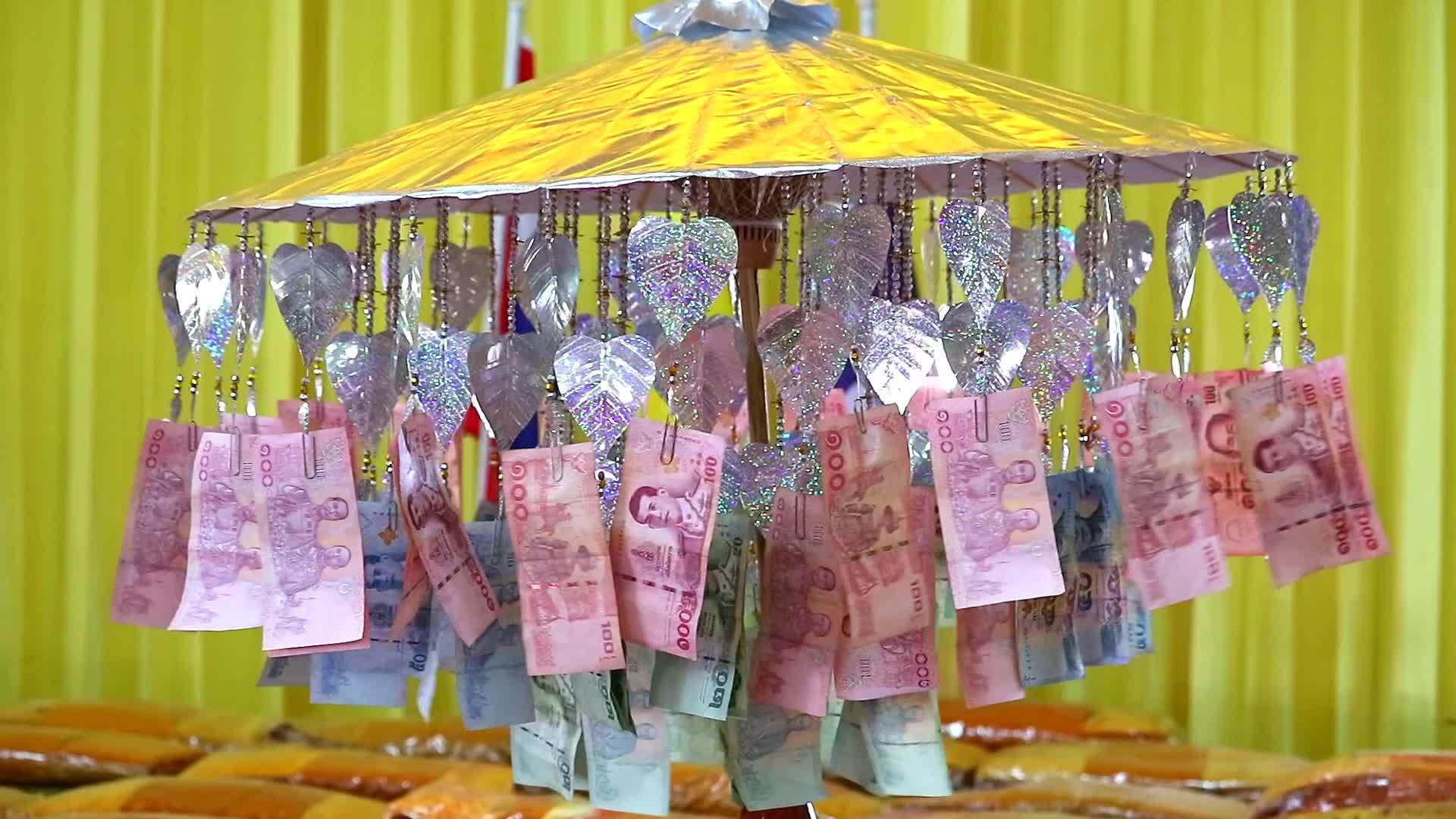 钱被精心折叠并装饰在金伞上献给佛教寺庙视频的预览图