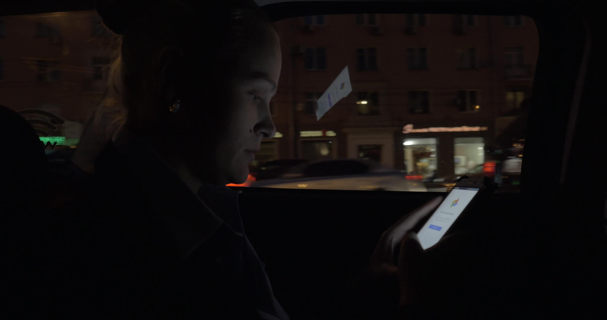 女性在晚上乘坐出租车时使用智能手机视频的预览图