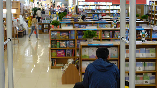 城市商业中心书店台阶上看书的人4k素材【该视频无肖像权，请勿商用】视频的预览图
