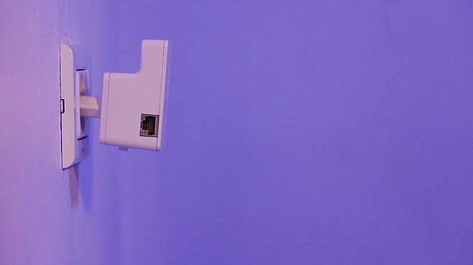 男人用手指按在WPS按钮上墙上的电插座wifi中继器上视频的预览图