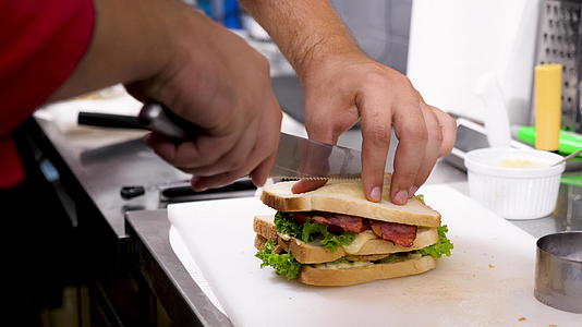 近距离暴露了烹饪手切三明治的镜头视频的预览图