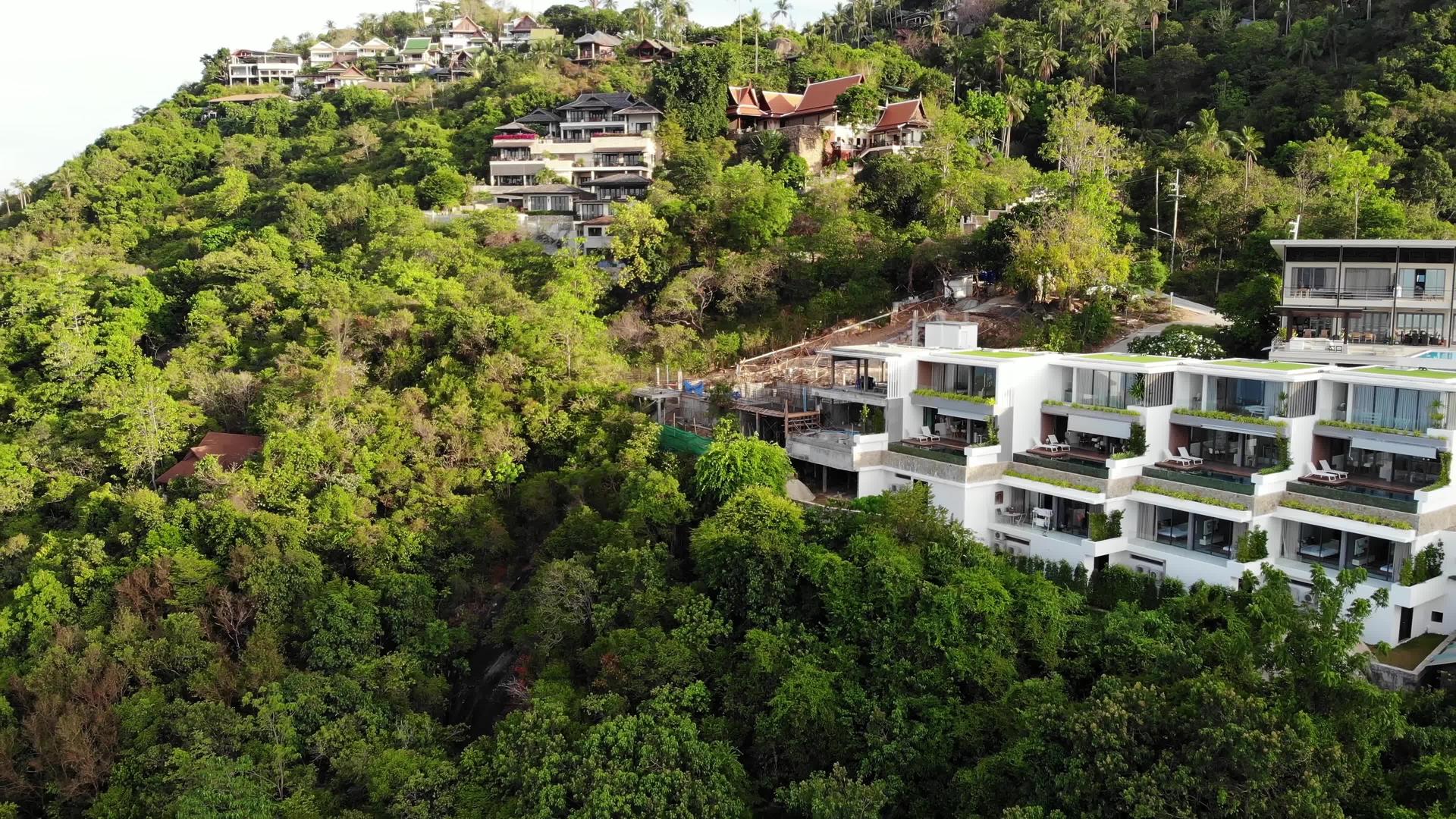 豪华别墅的宏伟无人机视图位于小海滩附近的热带天堂岛的绿色山脉上视频的预览图