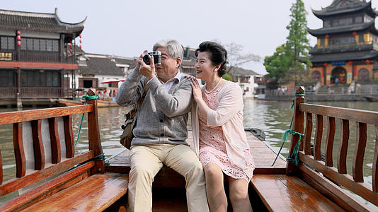 老年夫妇坐在人力船上拍照视频的预览图