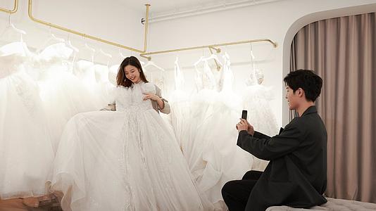 年轻情侣婚纱店拍照挑选婚纱视频的预览图