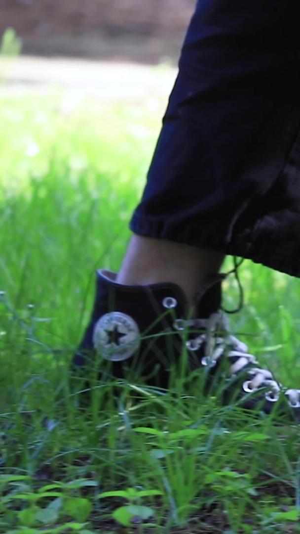 相机拍摄帆布鞋在秋天落叶草地上行走视频的预览图
