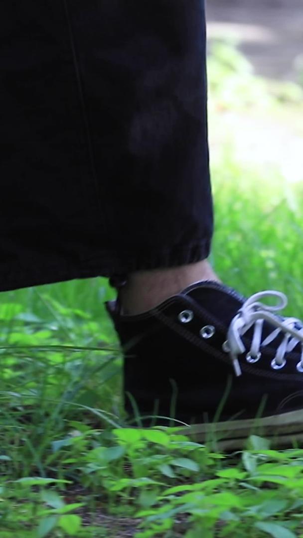 相机拍摄帆布鞋在秋天落叶草地上行走视频的预览图