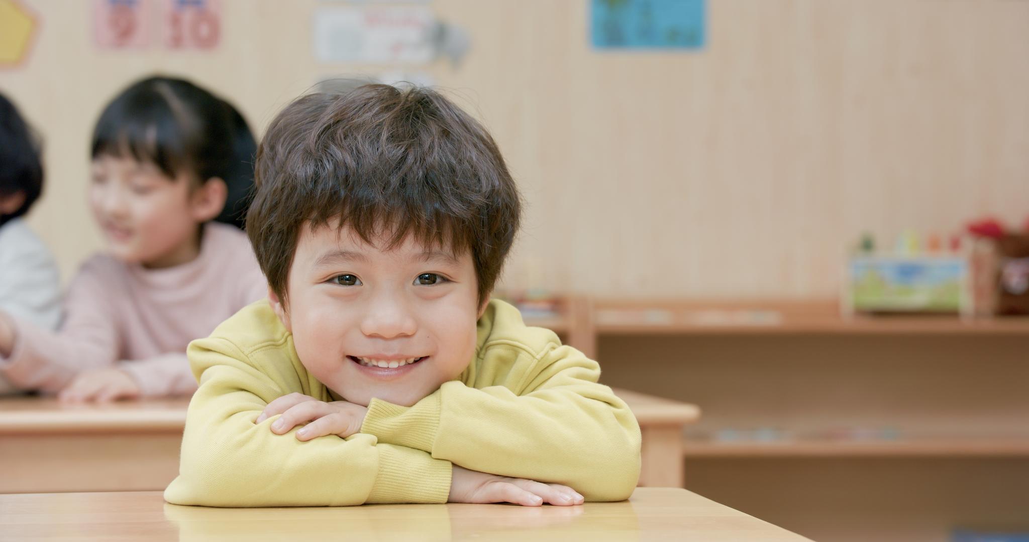 8K趴在课桌上开心微笑的小男孩视频的预览图