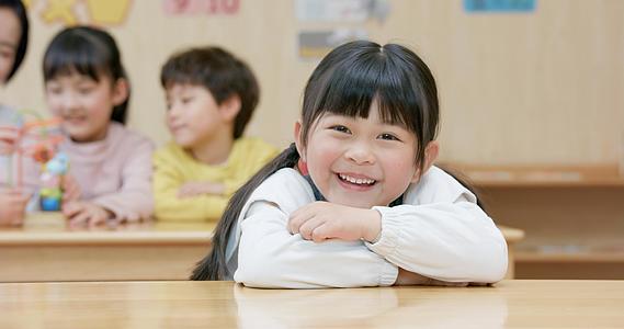 8K趴在课桌上开心微笑的小女孩视频的预览图