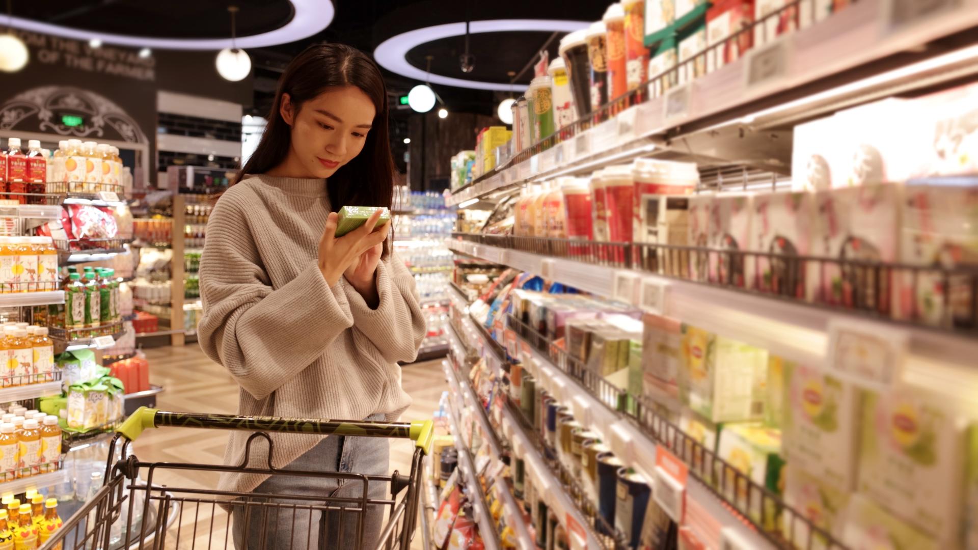超市推着购物车的女青年挑选商品视频的预览图