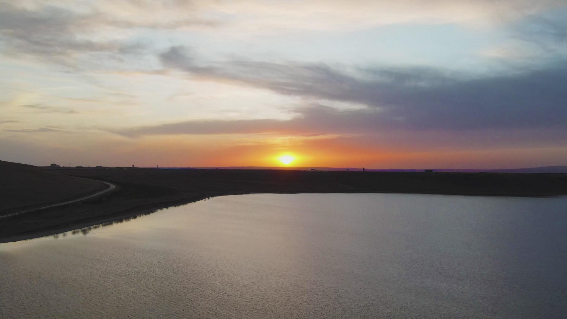 4k航拍夕阳西下波光湖面和连绵的山头视频的预览图