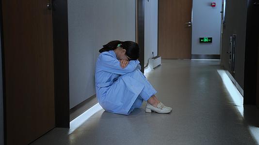 女性医护人员蹲坐在医院走廊难过沮丧视频的预览图
