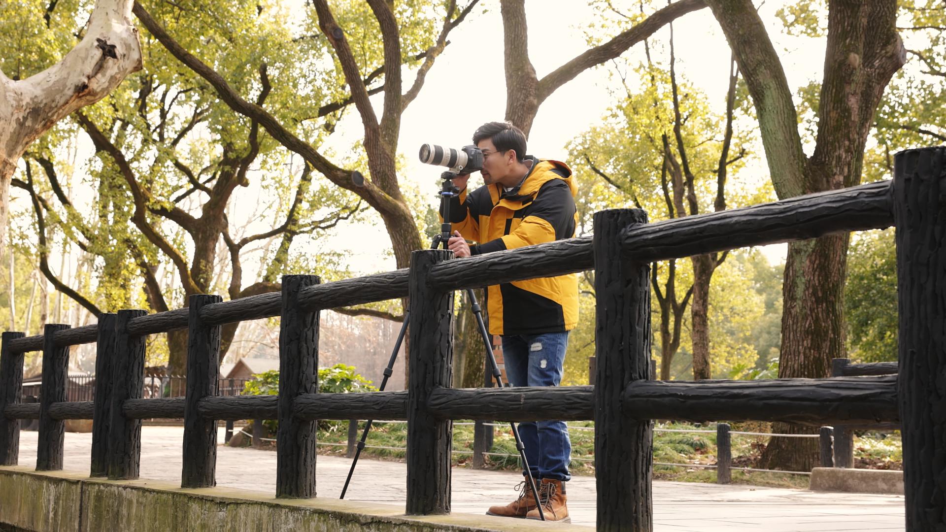 站在桥上的摄影师在拍照片视频的预览图
