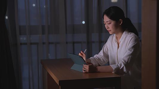 夜晚女性用平板电脑办公视频的预览图