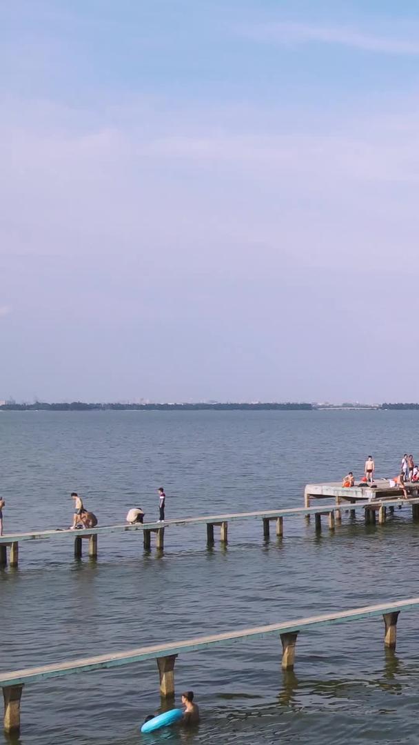 航拍城市风景夏日湖中游泳消暑的人群素材视频的预览图
