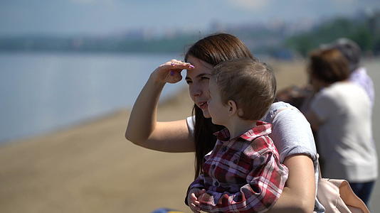 母亲和儿子在海边向前看视频的预览图