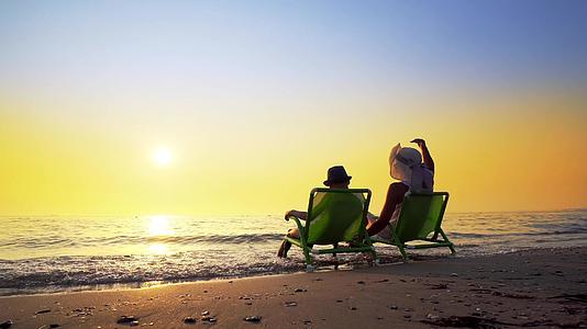 暑假期间母亲和儿子在海滩上享受日落视频的预览图