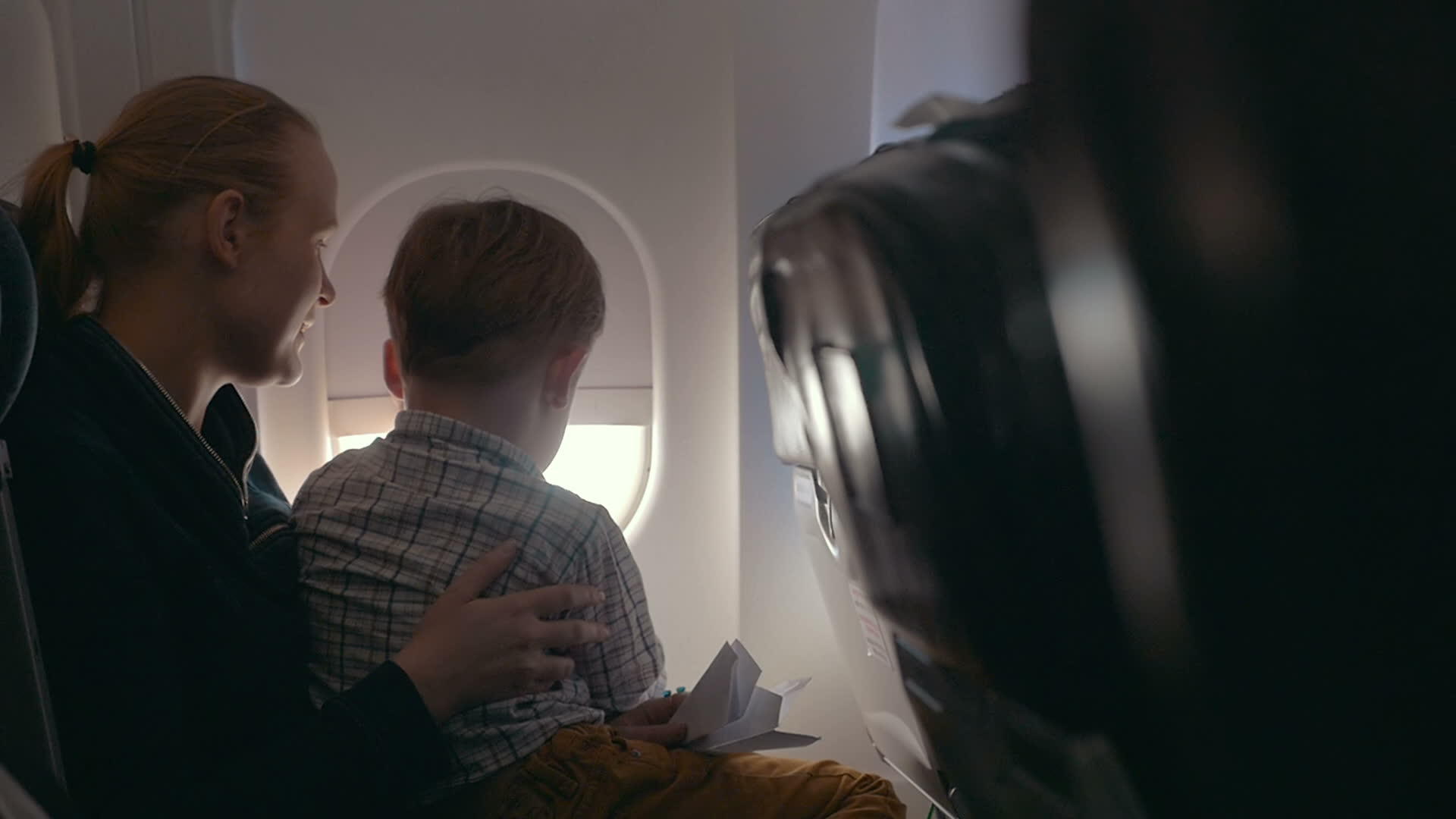 男孩和母亲透过飞机窗向外看视频的预览图