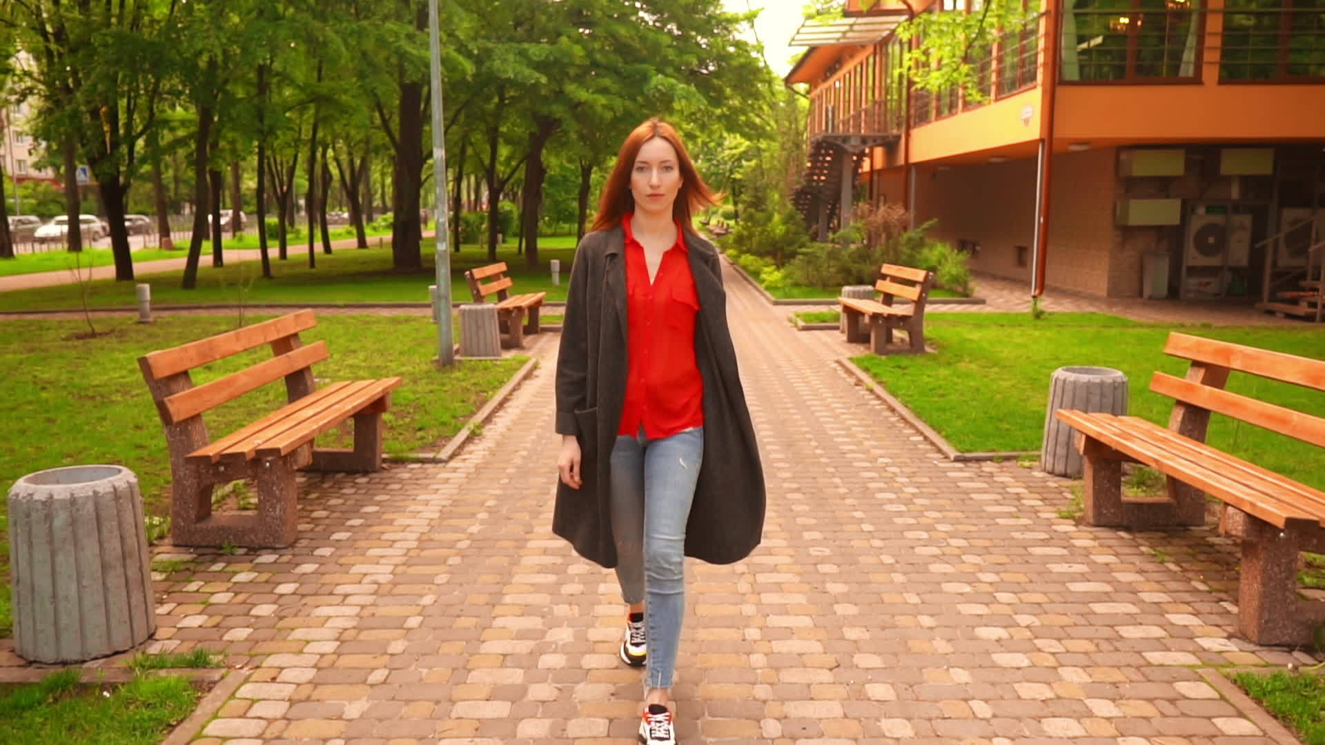 红头发的女人在绿树和草地上散步视频的预览图