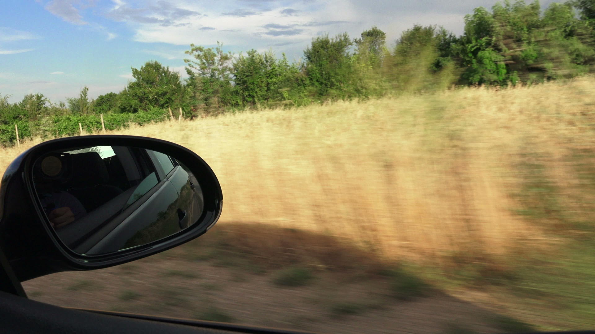 在农村道路上驾驶汽车后视镜的道路一侧视频的预览图