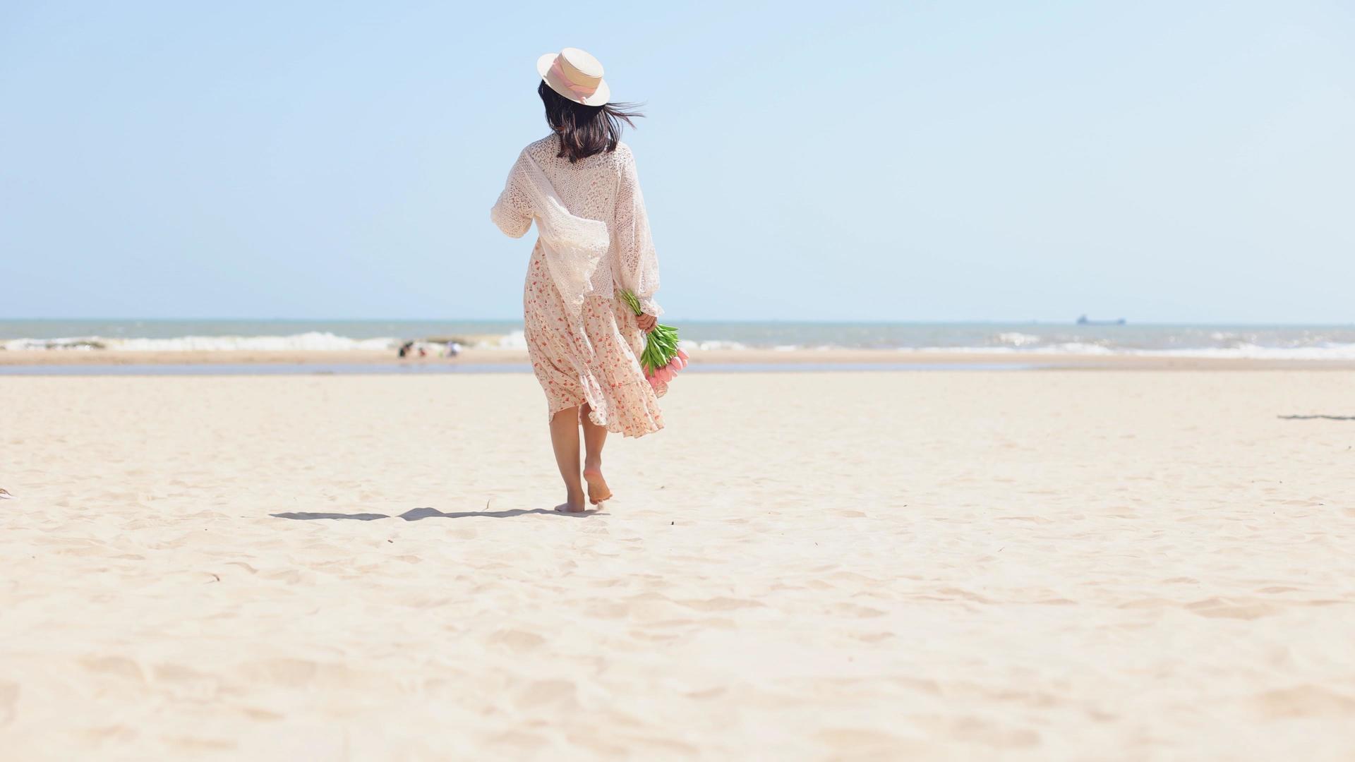 4k实拍唯美夏日海边行走在沙滩的女生背影视频的预览图