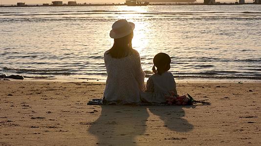 温馨母女海边沙滩坐着玩耍看日落视频的预览图