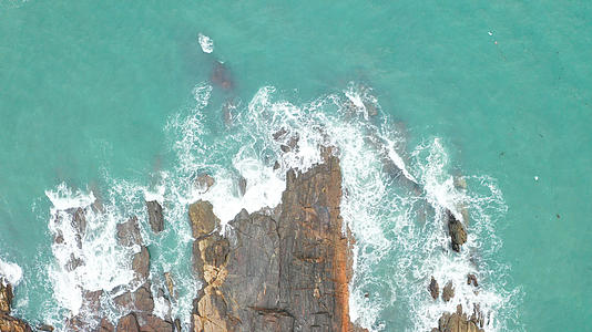 俯拍海浪拍打在礁石上视频的预览图