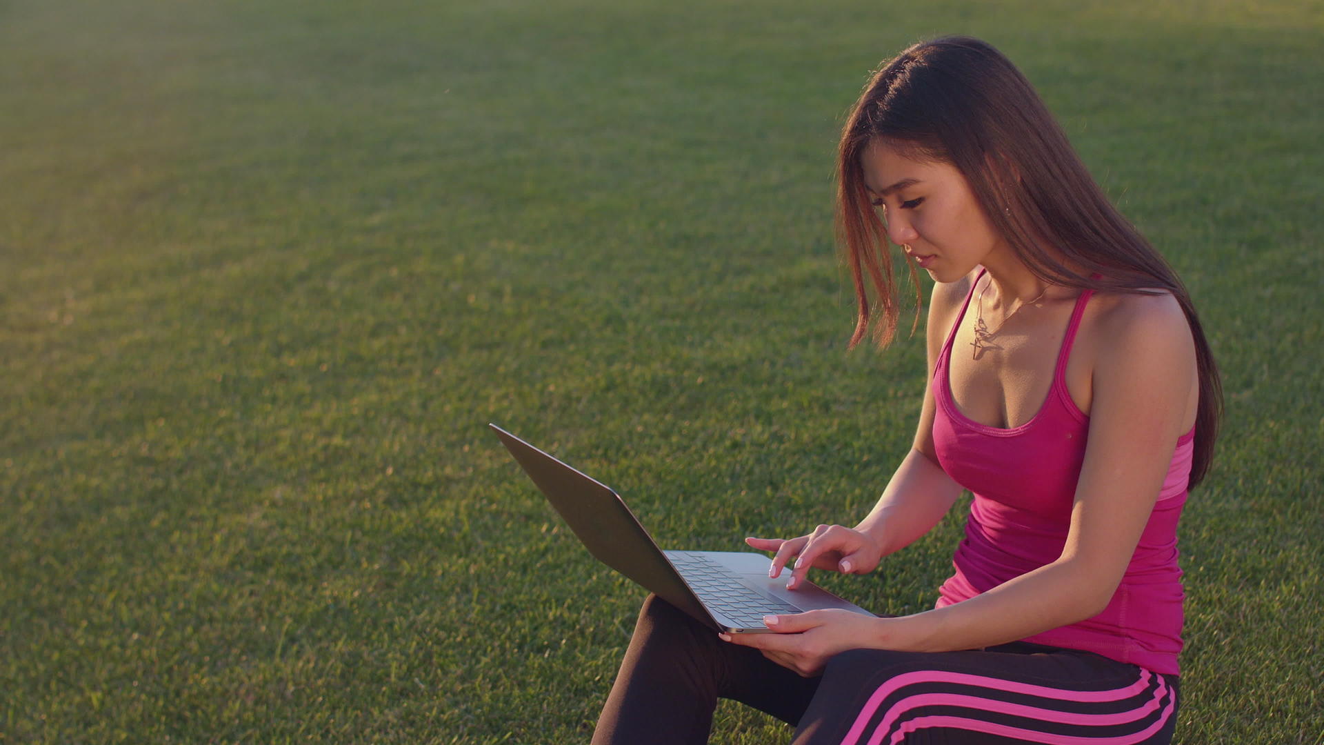 在草坪上练习瑜伽的女性拿起笔记本电脑工作视频的预览图