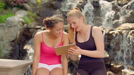 两名年轻女性用平板电脑聊天和分享视频的预览图