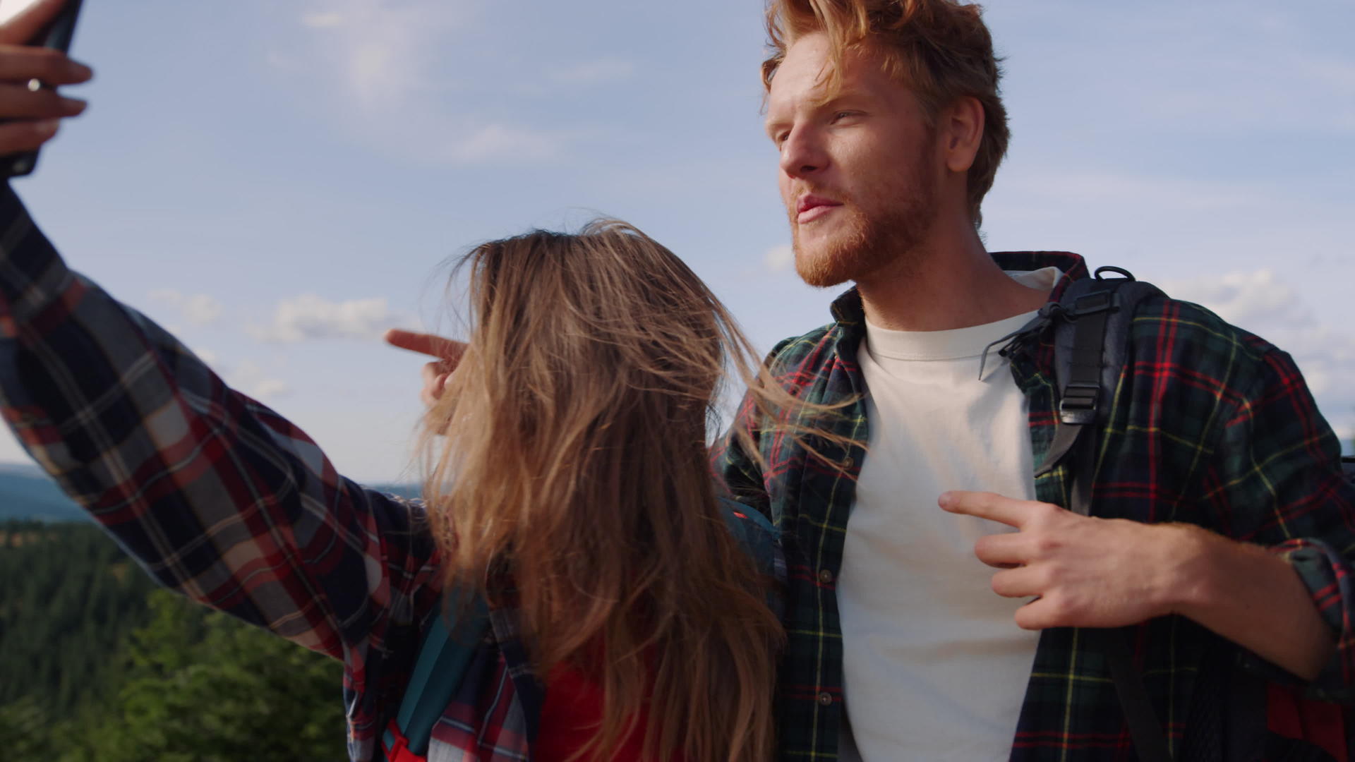 山顶上的年轻情侣用手机自拍视频的预览图