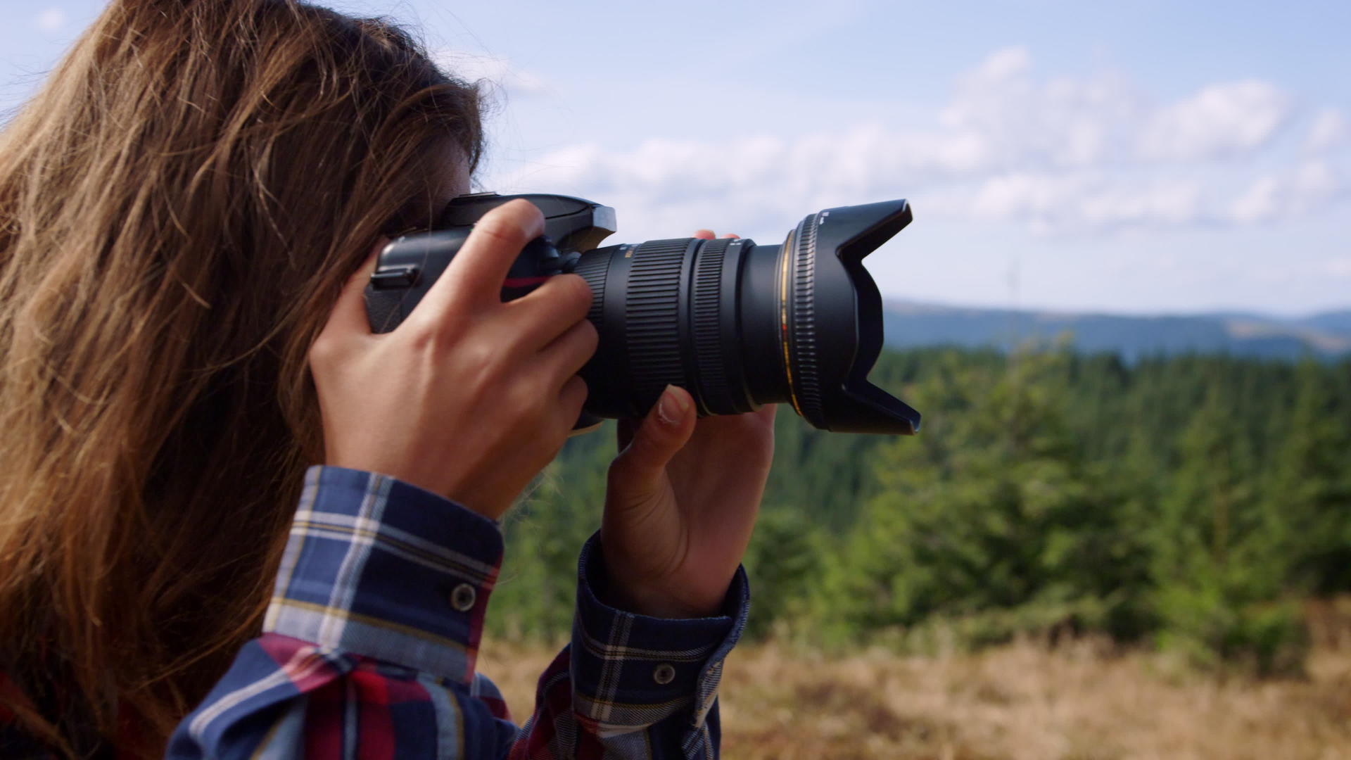 女摄影师在山顶拍摄视频的预览图