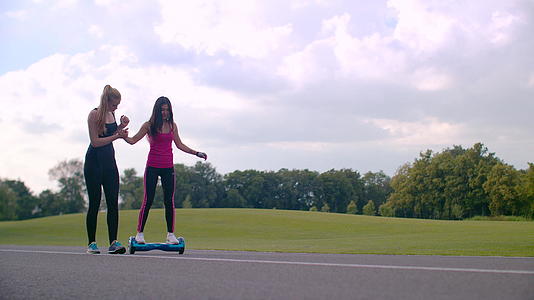 健身教练帮助女孩练习平衡车视频的预览图