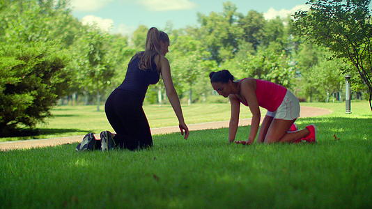 两个女人在公园草坪上做瑜伽视频的预览图