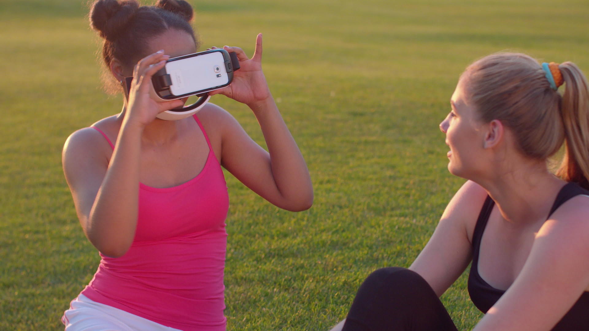两位年轻女性在草坪上体验草坪vr眼镜视频的预览图