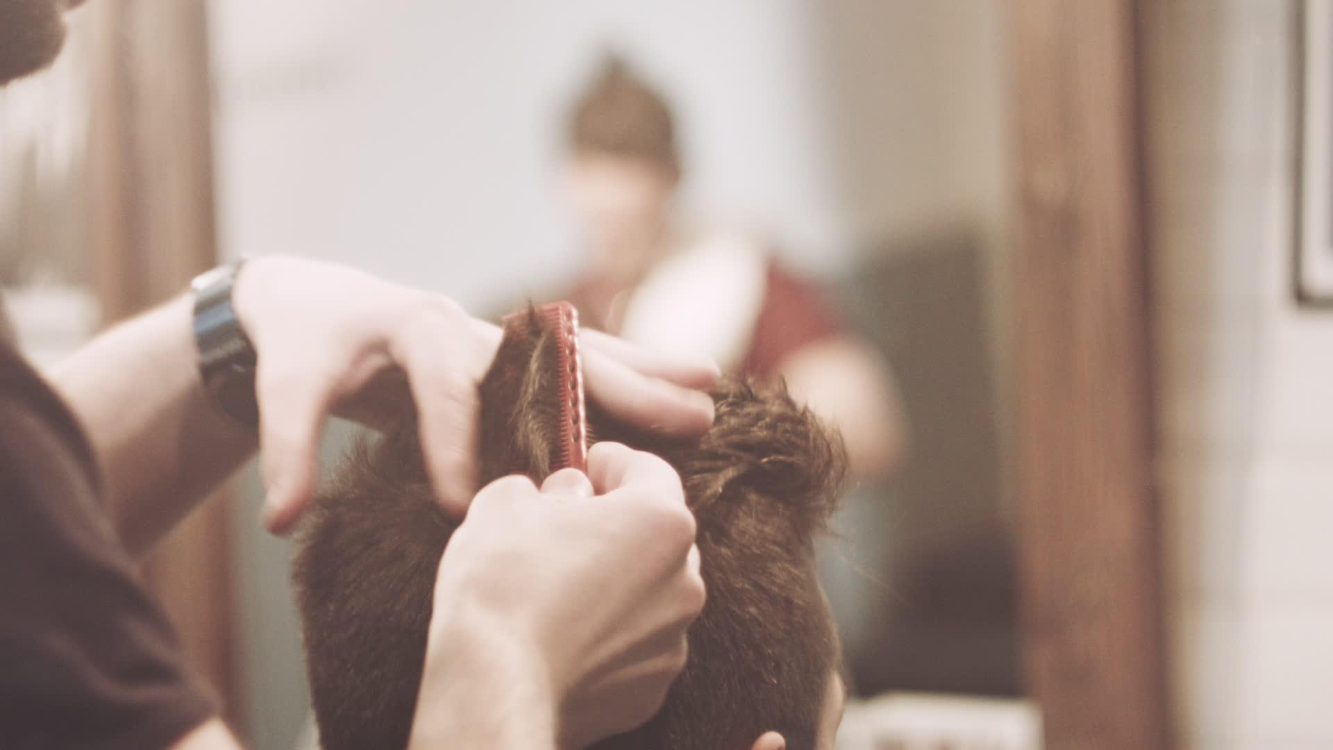 第一个视角看理发师修剪男性顾客的头发视频的预览图